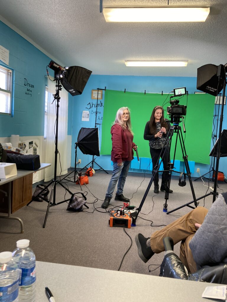 Cammera, lights, 2 ladies standing in front of green screen