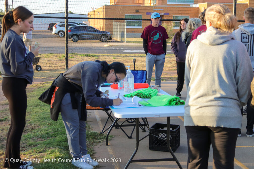 Volunteer signing name at registration table
